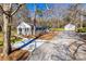 Inviting home with a concrete driveway, gray painted brick, black shutters, and a separate garage, surrounded by mature trees at 2478 Stribling Cir, Lancaster, SC 29720