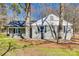 Side view of a gray brick house with a cozy porch, set amongst mature trees, showing the home's unique architecture at 2478 Stribling Cir, Lancaster, SC 29720