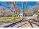 Charming gray house with a detached garage, driveway, nestled among mature trees on a lush lot at 2478 Stribling Cir, Lancaster, SC 29720