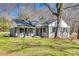 Charming single-story home with a gray brick facade, inviting front porch, and mature trees in a lush, green yard at 2478 Stribling Cir, Lancaster, SC 29720