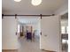 Open-concept living space with sliding barn doors leading to a dining room with classic furniture at 306 Stevens St, Monroe, NC 28112