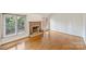 Spacious living room features hardwood floors, a brick fireplace with wood mantle, and ample natural light from large windows at 309 Settlers Ln, Charlotte, NC 28202