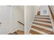 Bright staircase with hardwood steps and white risers, complemented by a wood handrail and a nearby closet at 309 Settlers Ln, Charlotte, NC 28202