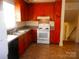 Functional kitchen with wood cabinets, white appliances, and easy access to the staircase at 3406 Erinbrook Ln, Charlotte, NC 28215