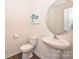 Half bath features a pedestal sink, round mirror and decorative wall art at 4010 Richard Andrew Dr, Matthews, NC 28105