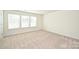 Spacious carpeted bedroom with natural light from the three large windows at 4010 Richard Andrew Dr, Matthews, NC 28105