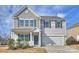 Charming two-story home features a covered entryway, light gray siding, and an attached two-car garage at 4010 Richard Andrew Dr, Matthews, NC 28105