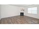 An empty room features a fireplace, window and dark-stained hardwood floors at 4010 Richard Andrew Dr, Matthews, NC 28105