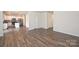 An empty room features a kitchen, staircase and hardwood floors at 4010 Richard Andrew Dr, Matthews, NC 28105