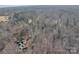 Aerial view of a house surrounded by trees showing the long driveway and roof at 530 Wilmot Trl, Gastonia, NC 28056