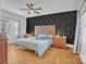 Bedroom features a statement wall with geometric black panels, complemented by hardwood floors and matching nightstands at 530 Wilmot Trl, Gastonia, NC 28056