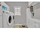 The laundry room is equipped with front-loading machines, storage cabinets, and a window for natural light at 530 Wilmot Trl, Gastonia, NC 28056