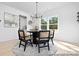 Bright dining area features modern light fixture, round wood table, and decor by the window at 680 Candela Ct # 52, York, SC 29745