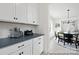 White cabinets and countertops are showcased in this bright kitchen, looking into the dining room with a view of outdoors at 680 Candela Ct # 52, York, SC 29745
