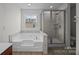 Bathroom featuring a soaking tub next to a glass-enclosed shower at 7007 Church Wood Ln, Huntersville, NC 28078
