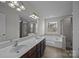 Bathroom with double sink vanity, soaking tub, and glass-enclosed shower at 7007 Church Wood Ln, Huntersville, NC 28078