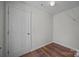 Bedroom with neutral wall color, wood floors, and white door at 7007 Church Wood Ln, Huntersville, NC 28078