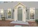 Close-up of the front door, featuring decorative columns, arched transom window and lantern sconces at 7007 Church Wood Ln, Huntersville, NC 28078