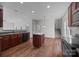 Bright kitchen featuring hardwood floors, island with white countertop, and dark wood cabinetry at 7007 Church Wood Ln, Huntersville, NC 28078