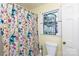 Colorful bathroom showcasing a floral shower curtain and a stained-glass window at 968 Waverly Ave, Rock Hill, SC 29730