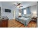 Bedroom with hardwood floors, ceiling fan, stylish bedding, and access to bathroom at 968 Waverly Ave, Rock Hill, SC 29730