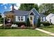 Charming blue home featuring a welcoming yellow door, lush landscaping, and a well-maintained lawn at 968 Waverly Ave, Rock Hill, SC 29730