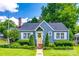 Charming blue home featuring a bright yellow door with a wreath and well-manicured lawn and landscaping at 968 Waverly Ave, Rock Hill, SC 29730