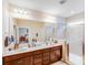 Bright bathroom with double vanity, spacious mirror, and a glass-enclosed shower providing a luxurious and functional space at 11135 Bailey Park Nature Dr, Cornelius, NC 28031
