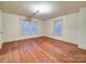 Bright bedroom featuring hardwood floors, two large windows, and neutral paint at 113 2Nd St, Spencer, NC 28159