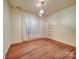 Bedroom featuring wood floors, a vintage light fixture, and a window, creating a cozy space at 113 2Nd St, Spencer, NC 28159