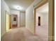 Bright hallway featuring neutral walls, carpet flooring, and multiple doorway entrances at 113 2Nd St, Spencer, NC 28159