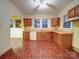 Functional kitchen features wood cabinets, double sink, and brick-patterned flooring at 113 2Nd St, Spencer, NC 28159