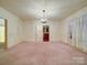 Spacious living room with carpet flooring, chandelier lighting, and entryways to other rooms at 113 2Nd St, Spencer, NC 28159