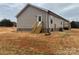 View of the home exterior with small back deck and tan siding at 133 Plank Barn Ln, Stony Point, NC 28678