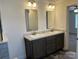Bathroom with double sinks, marble countertops, and dark wood cabinetry at 133 Plank Barn Ln, Stony Point, NC 28678