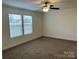 Bright bedroom featuring a ceiling fan, plush carpet, and a window that lets in natural light at 133 Plank Barn Ln, Stony Point, NC 28678