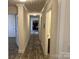Long hallway featuring wood grain floors and neutral wall color leads to various rooms at 133 Plank Barn Ln, Stony Point, NC 28678