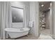 Relaxing bathroom with freestanding tub, window with curtain, and glass shower with tile wall at 17639 Stuttgart Rd, Davidson, NC 28036