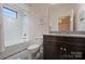 Well-lit bathroom with a tub/shower combo, granite countertop, and elegant fixtures at 17639 Stuttgart Rd, Davidson, NC 28036