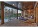 Inviting covered patio with a stone fireplace, comfortable seating, and pool views at 17639 Stuttgart Rd, Davidson, NC 28036