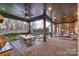 Spacious covered patio with a stone fireplace, outdoor kitchen, and pool view at 17639 Stuttgart Rd, Davidson, NC 28036
