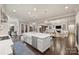 Bright, open kitchen with a large island, stainless steel appliances, and hardwood floors, flowing into the living room at 17639 Stuttgart Rd, Davidson, NC 28036