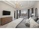 Bright main bedroom with a chandelier, furniture, tray ceiling, and a large window at 17639 Stuttgart Rd, Davidson, NC 28036