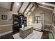 Home office with vaulted ceiling, exposed beams, custom built-in bookshelves, and a comfortable seating area at 17639 Stuttgart Rd, Davidson, NC 28036