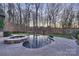 Backyard in a wooded area with a large custom pool and stone patio at 17639 Stuttgart Rd, Davidson, NC 28036