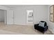 Large bedroom features neutral tones, an open entrance to an adjoining ensuite, and a dark colored side chair at 2461 Palmdale Walk Dr, Fort Mill, SC 29708