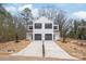 Modern, white two-story home featuring a double garage and a long, concrete driveway at 2811 New Pineola Rd, Charlotte, NC 28208
