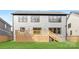 Large backyard featuring a wooden deck with stairs leading to a green lawn, and a modern home exterior at 3907 Plainview Rd, Charlotte, NC 28208