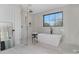 Modern bathroom features a soaking tub, walk-in shower, and a large window offering plenty of natural light at 3907 Plainview Rd, Charlotte, NC 28208