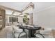 Elegant dining room with dark wood table, modern chandelier and open view to the living room and stairway at 3907 Plainview Rd, Charlotte, NC 28208